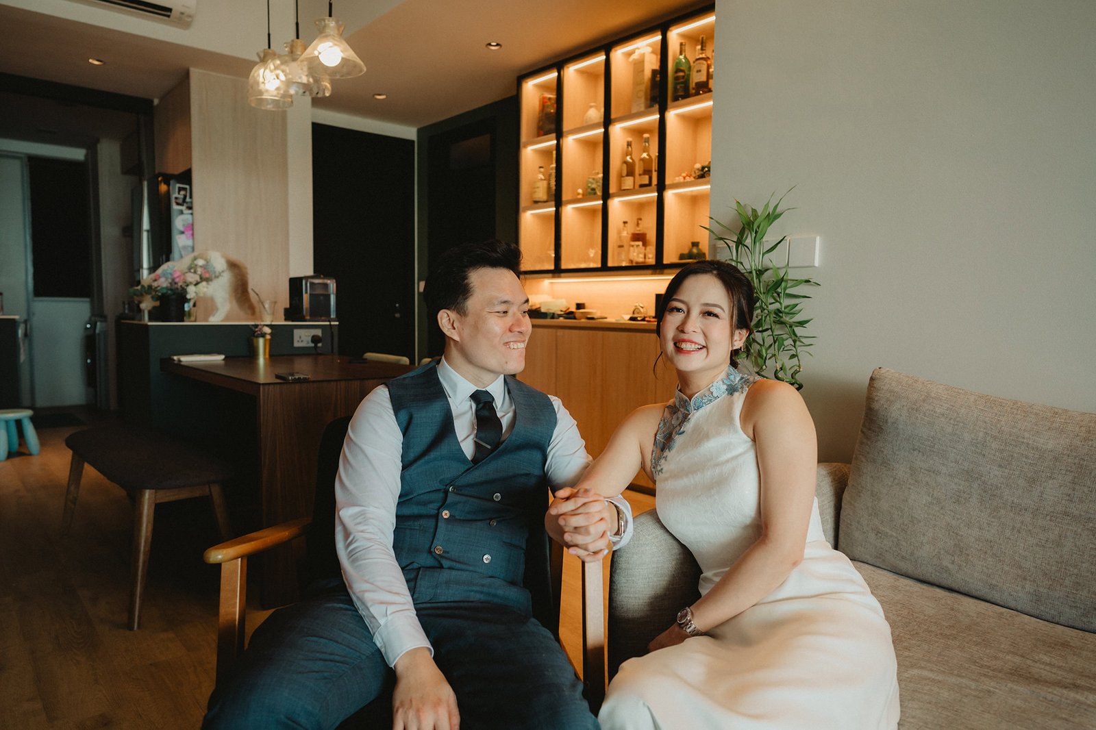 Han and Ming, a couple, holding hands and smiling at their Capella Singapore wedding.