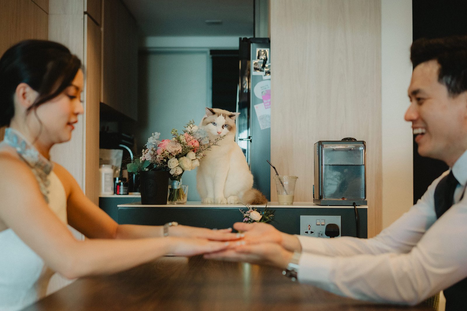 Capella Singapore wedding: Couple holds hands with cat and flowers