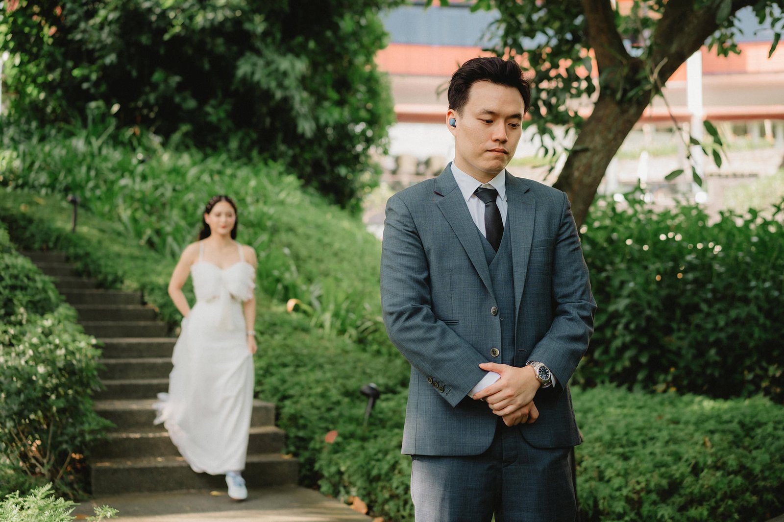 Groom waits at Capella Singapore wedding as bride descends stairs