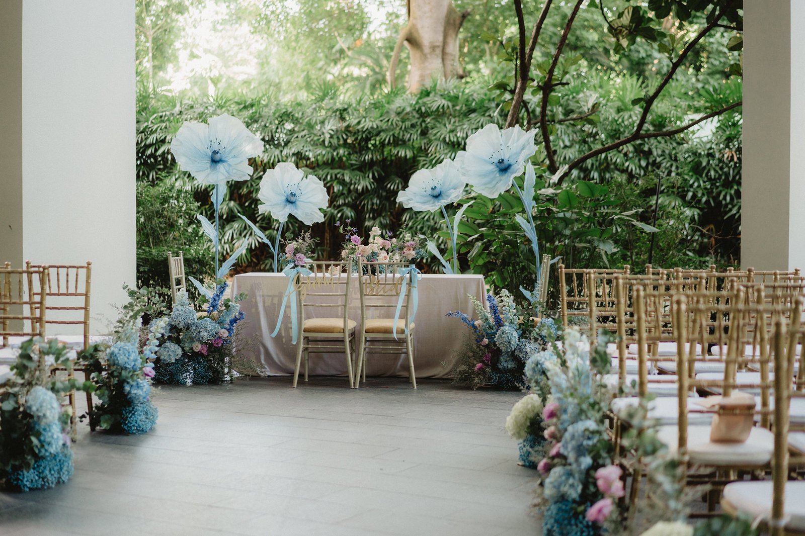 Capella Singapore wedding: elegant ceremony setup with blue flowers & large white poppies