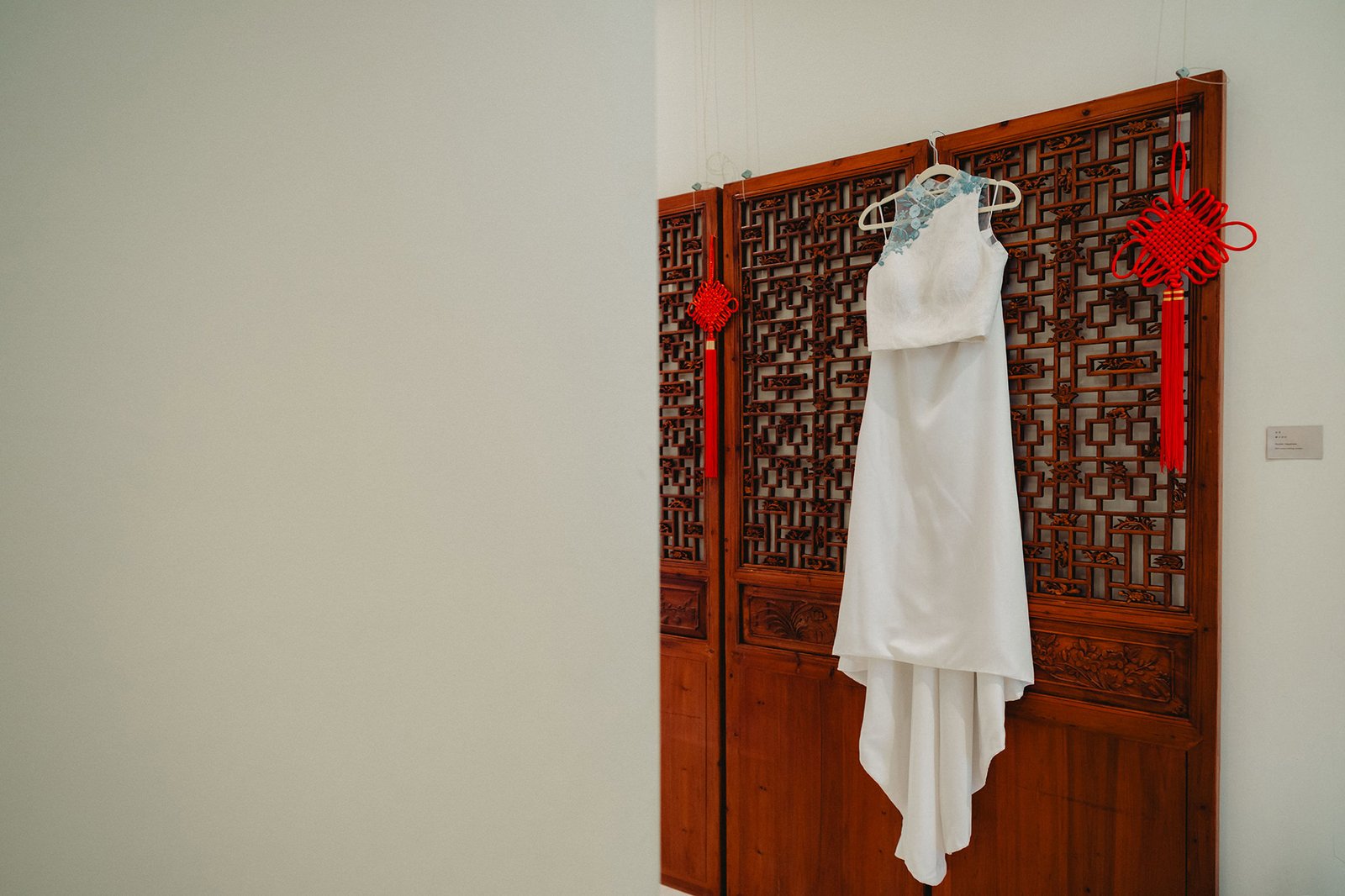 White wedding dress hanging on ornate wooden screen at Capella Singapore wedding