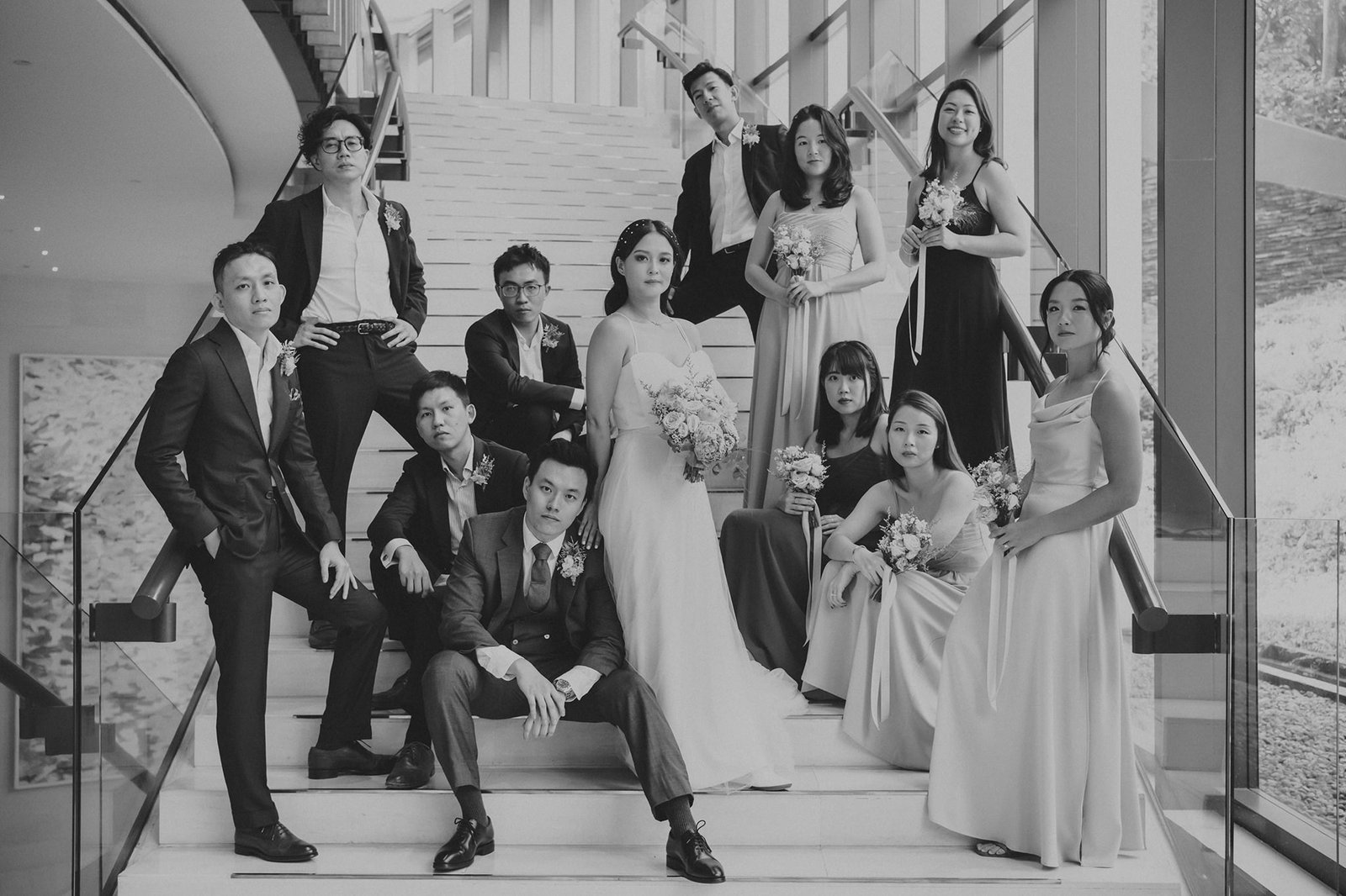 Wedding party at Capella Singapore: bride, groom, and attendants on stairs