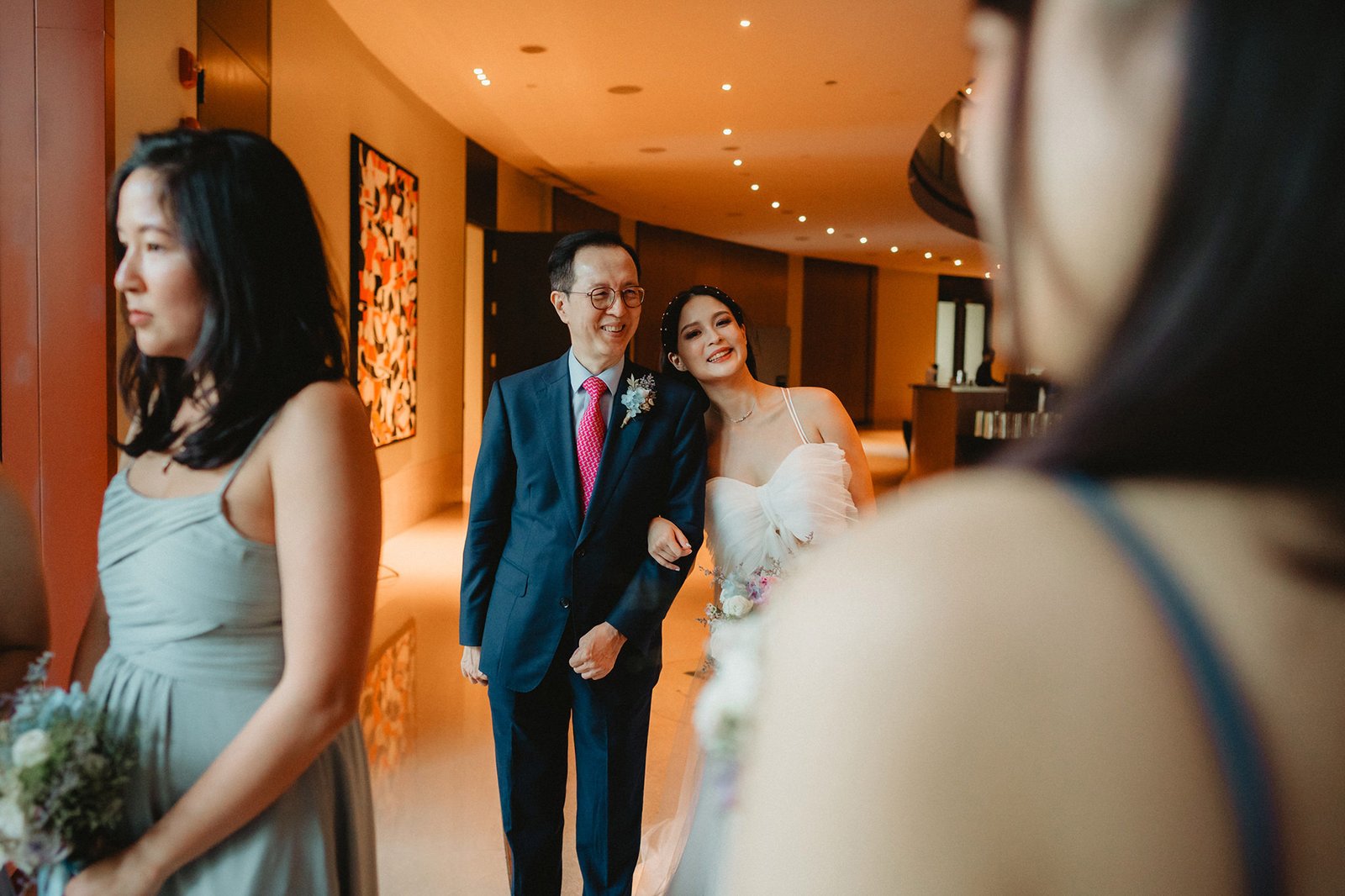 Bride leans on father at Capella Singapore wedding, with bridesmaids nearby.