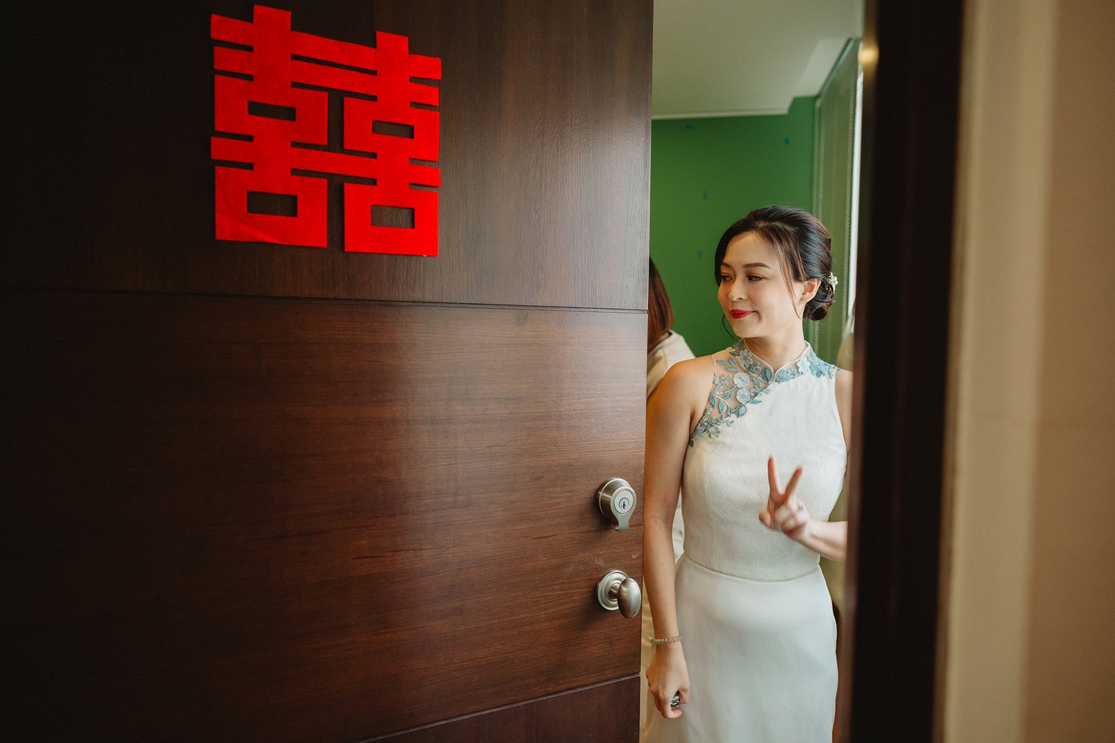 Bride in cheongsam at Capella Singapore wedding, double happiness symbol on door