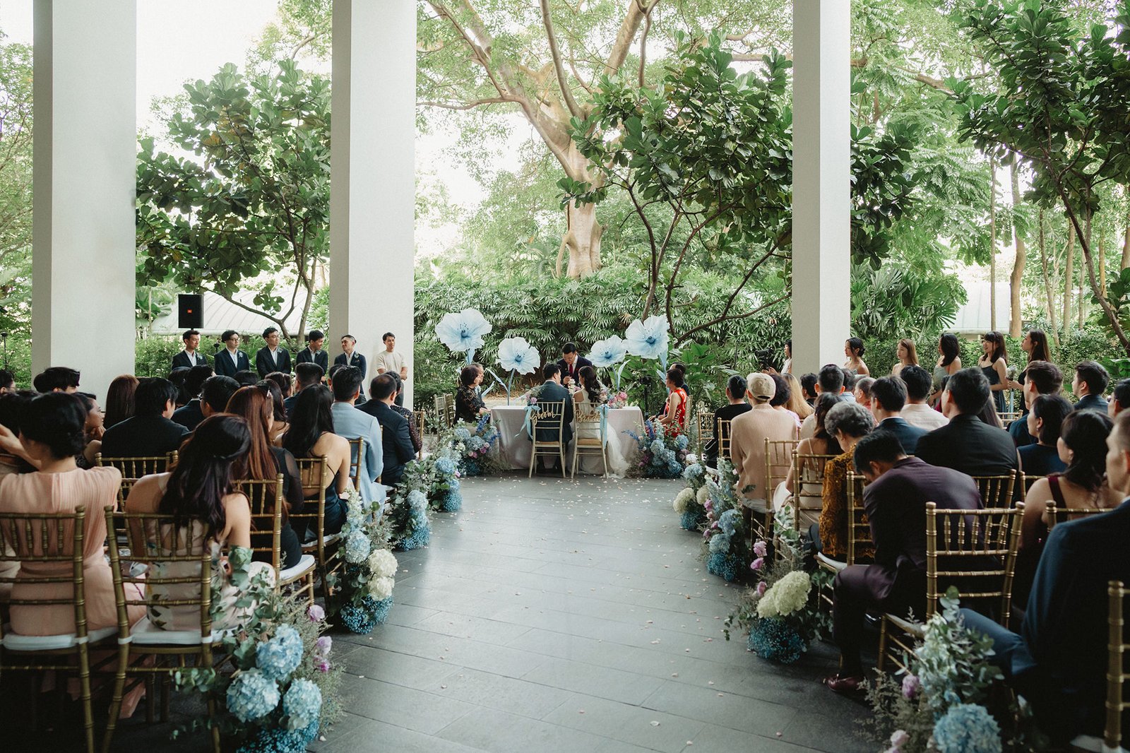 Capella Singapore wedding ceremony with guests seated outdoors.