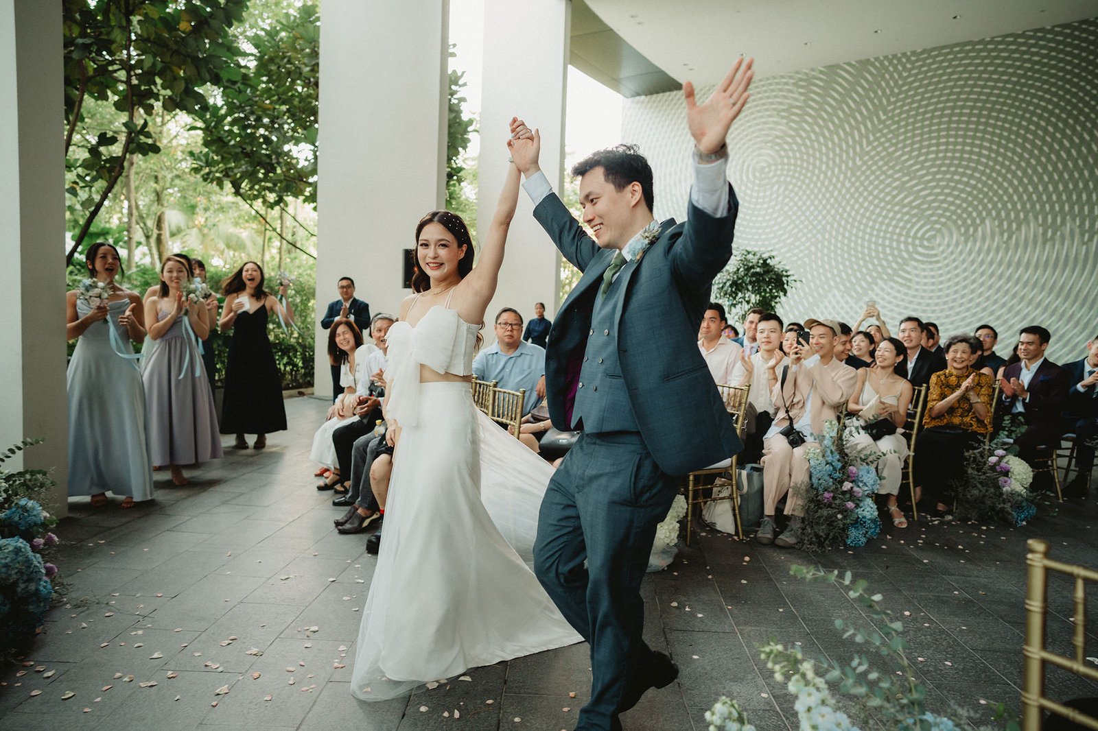 Newlyweds Han and Ming celebrate their Capella Singapore wedding, cheered by guests.
