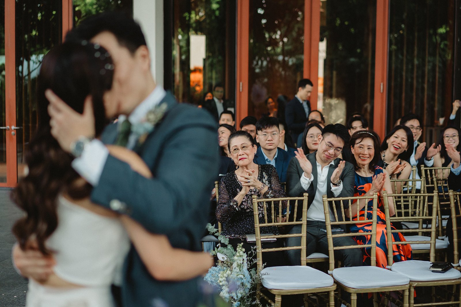 Couple kissing at Capella Singapore wedding, guests watching