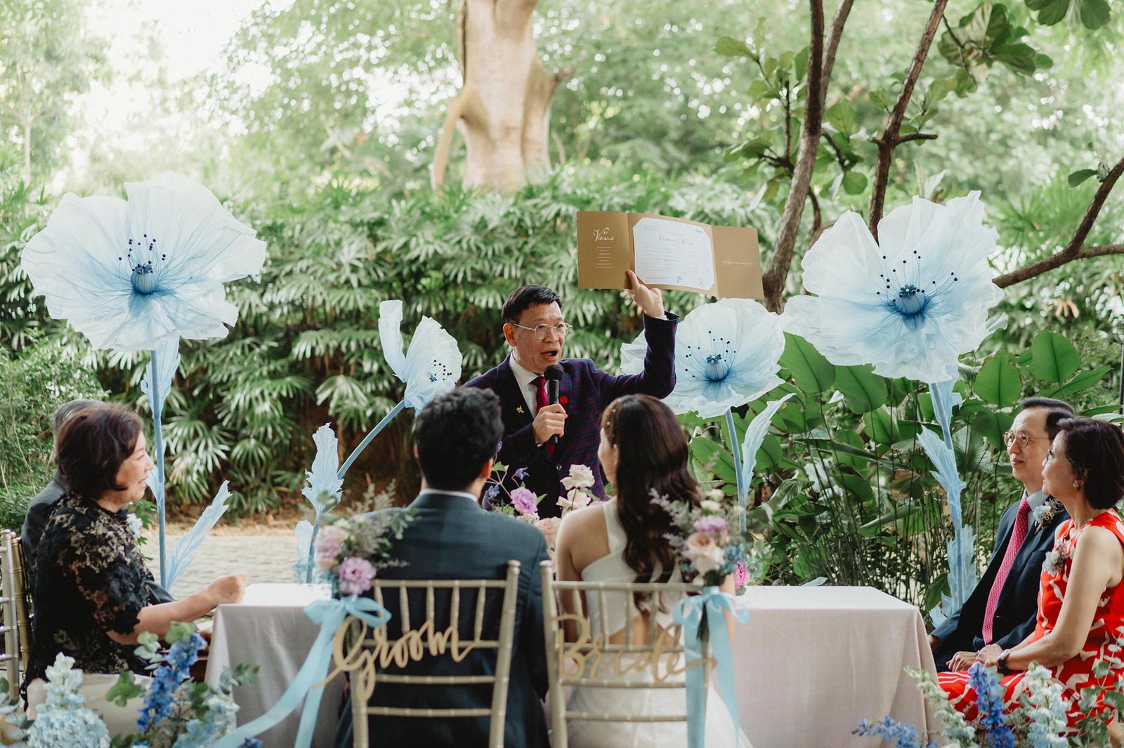 Officiant holding certificate at Capella Singapore wedding ceremony for Han + Ming