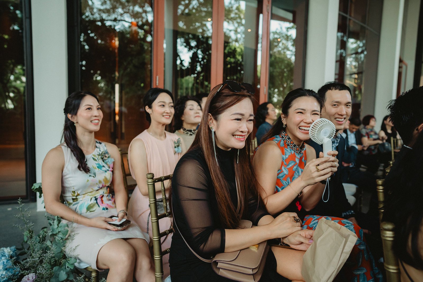 Guests at Capella Singapore wedding, including a woman fanning herself