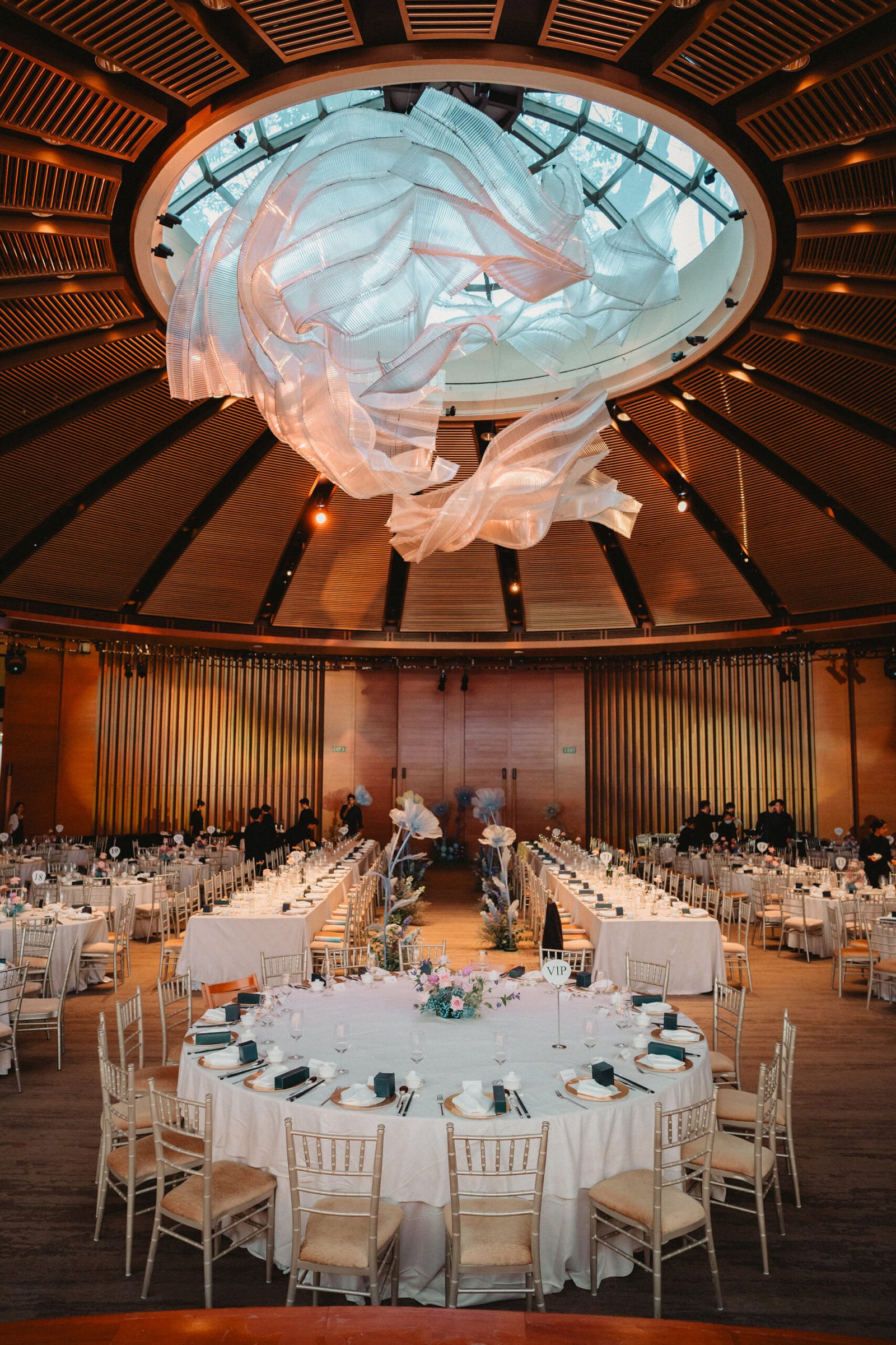 Capella Singapore wedding reception setup with round tables and grand chandelier