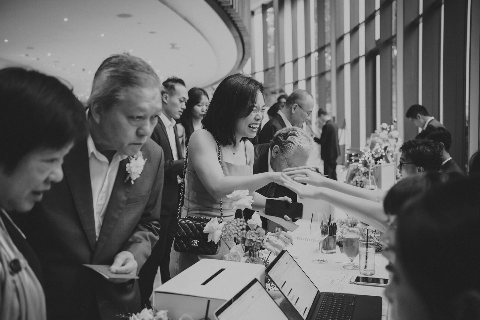 Guests at a Capella Singapore wedding, including Han and Ming, mingle and laugh at a reception.