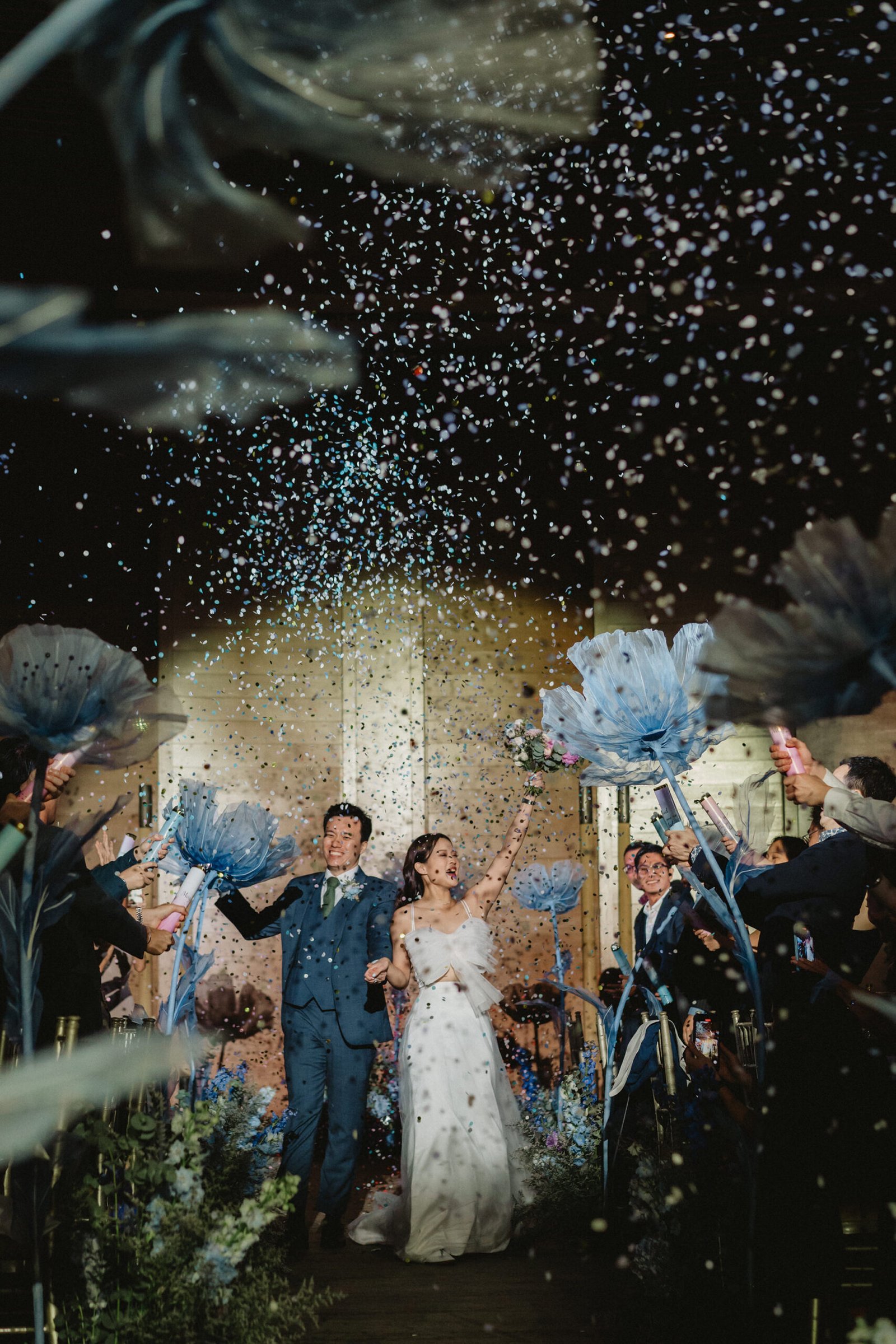 Capella Singapore wedding: Han and Ming exit with confetti and blue flowers.