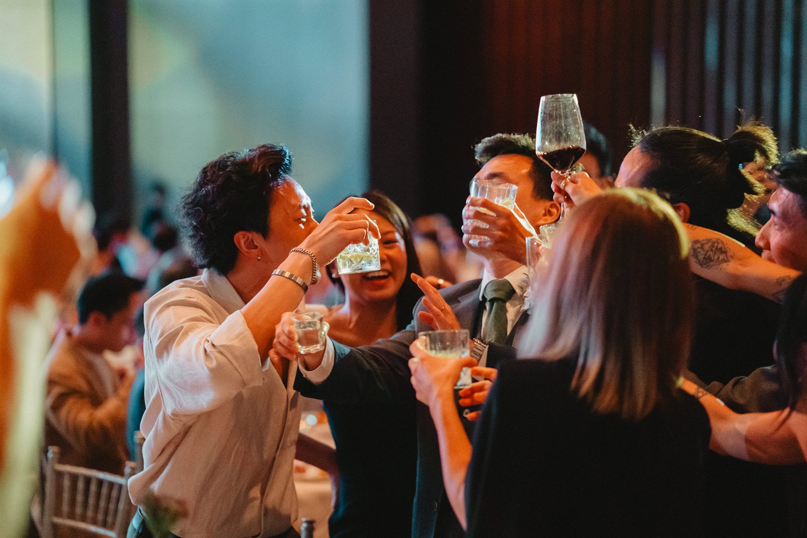 Chasing Dragons wedding at Capella Singapore: Guests toast during a joyous celebration.