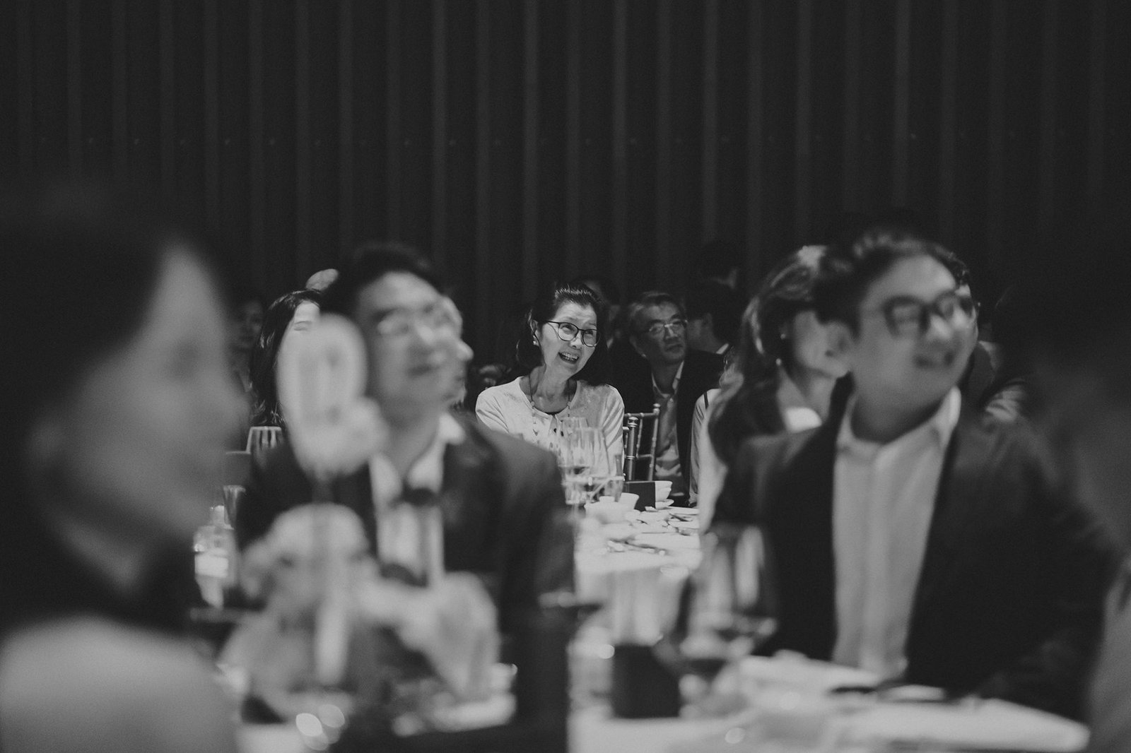 Guests at a Capella Singapore wedding reception, with a woman smiling in the center.